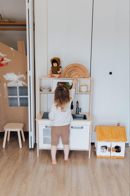 Child engaging with play kitchen